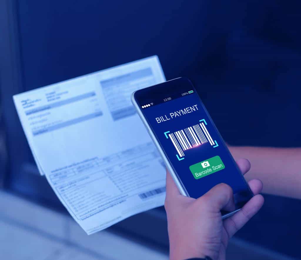 A man uses a phone to scan and pay his bill digitally and remotely.