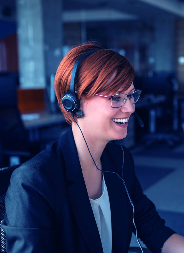 A business woman smiling wearing a headset