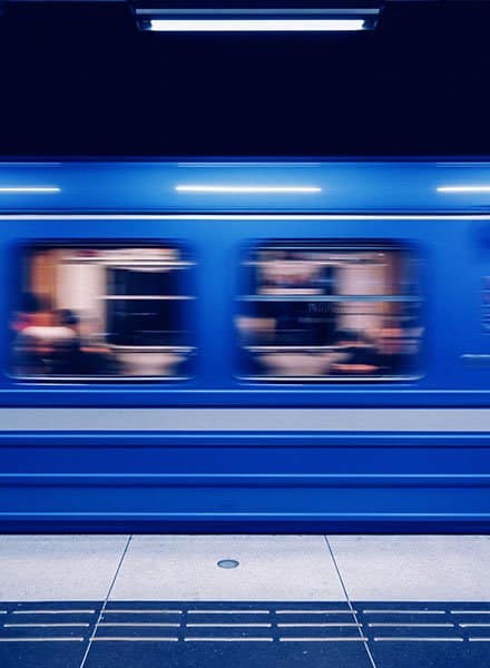 View from train platform of a blue train with motion blur