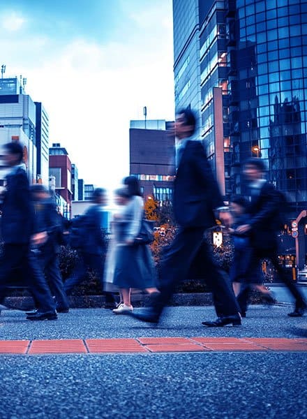 People in motion blur walking down the road of a city