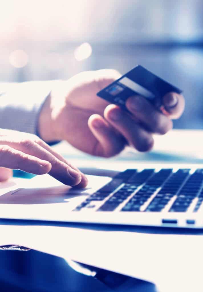 Someone making a payment by credit card on their laptop