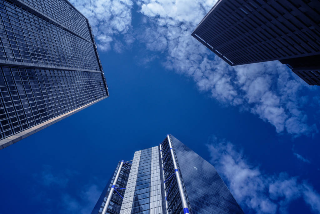 Skyscrapers against blue sky with some clouds.