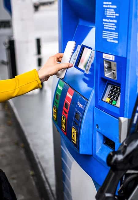 A woman pays for her gas wirelessly using her phone.