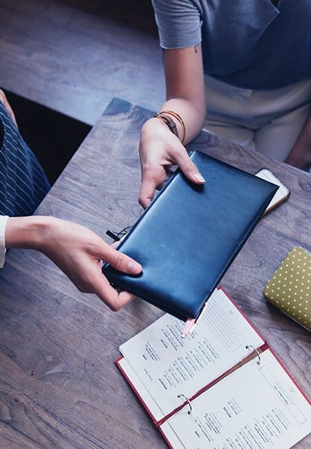 Two people are handling a bill at a restaurant 