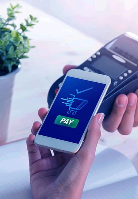 A woman holds out her phone to wirelessly pay for her purchase at the hand held point of sale system. 