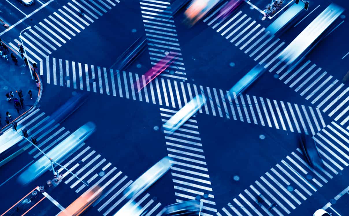 A city street crossing seen from above, there is blur from the cars rushing past.