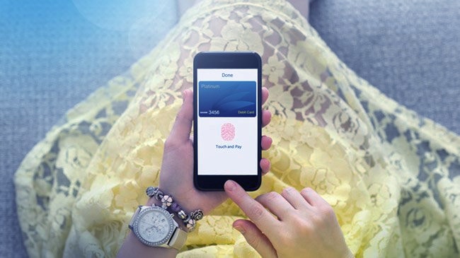 A point of view shot of a woman looking down at her phone, using fingerprint authentication to complete a purchase.