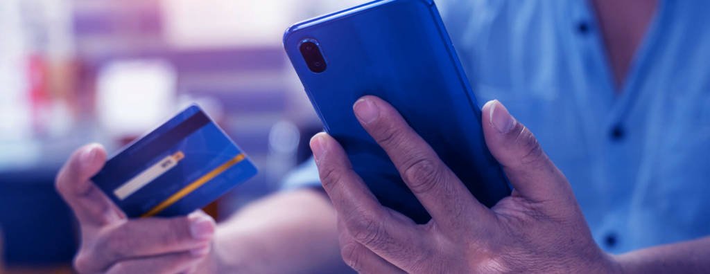 Person holding up a phone and a credit card