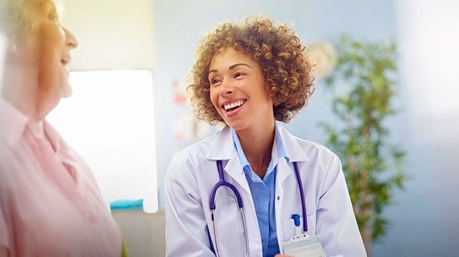 Woman doctor smiles at her elderly patient