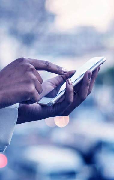 A woman typing on her touch screen smart phone