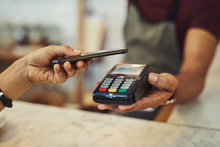 Customer making mobile payments using NFC at in-store POS device