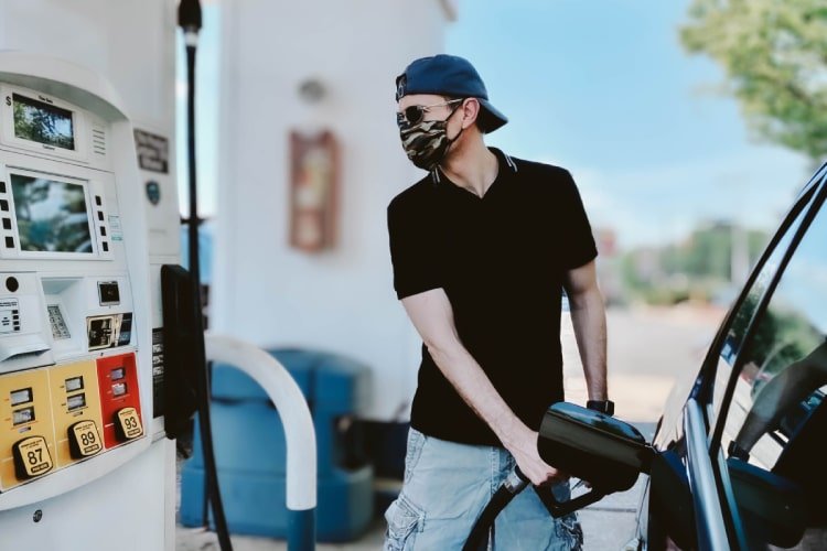 Man pumping gas into car at gas station