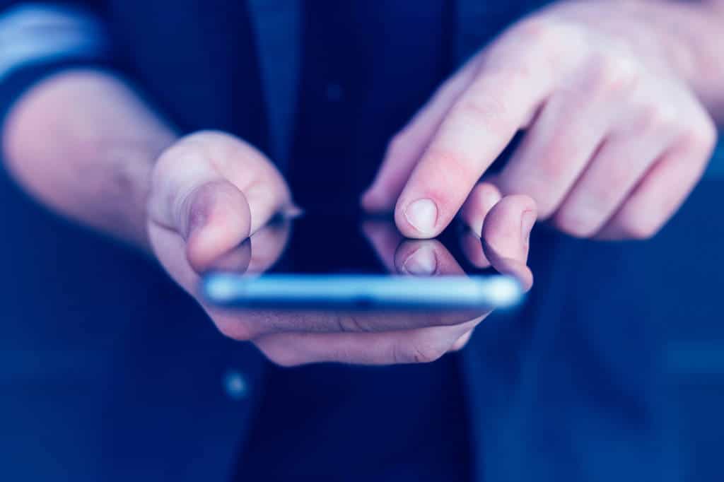 Index finger of young man touching smartphone