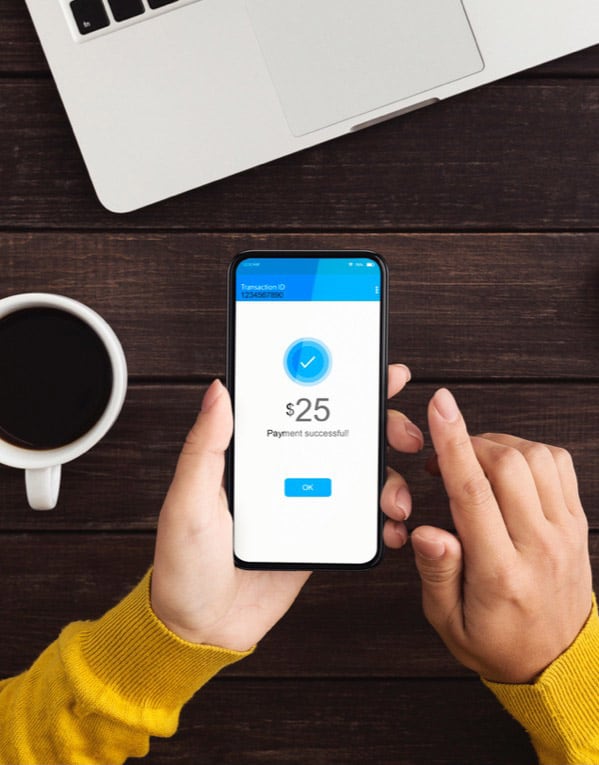 Woman with cellphone making digital payment