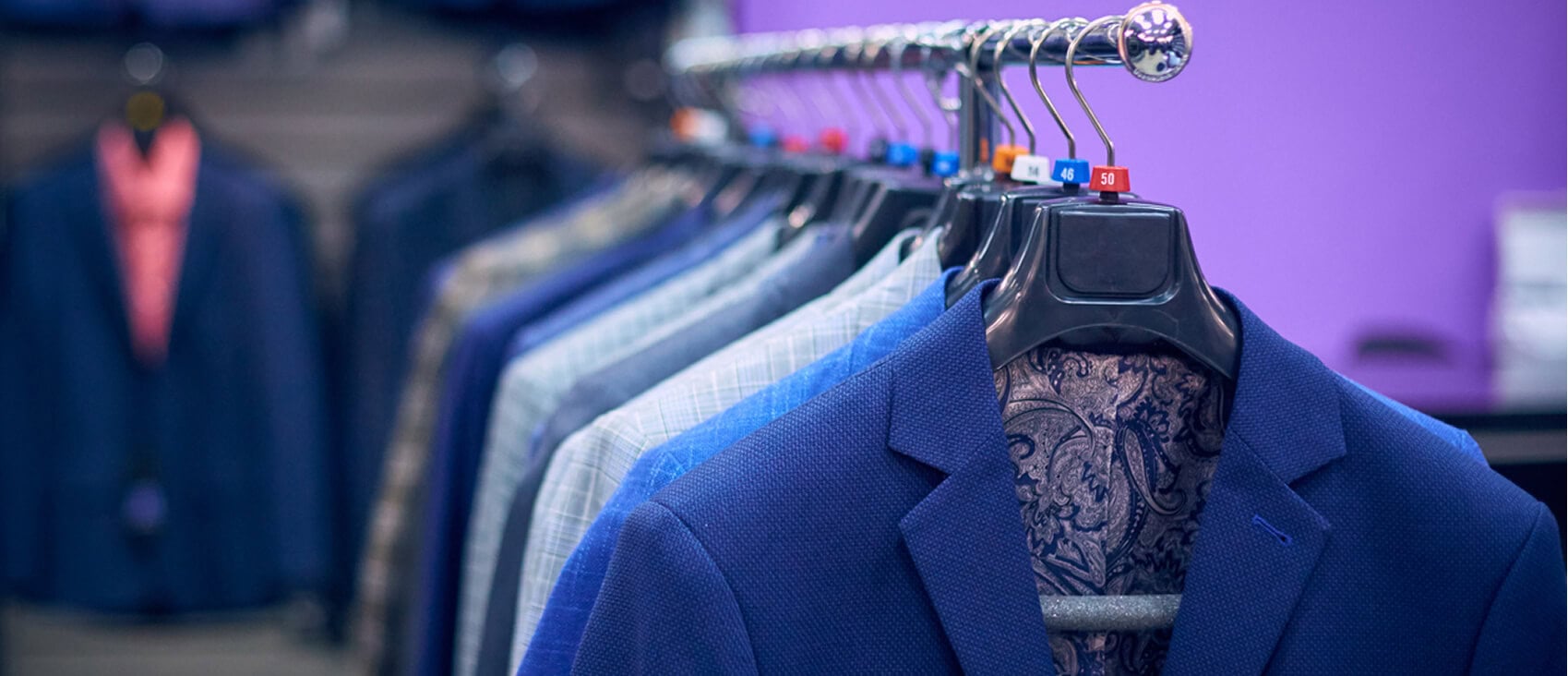 suits hanging on rack in a brick and mortar retail store.