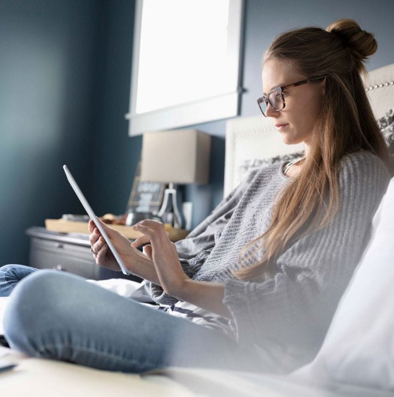 Woman using tablet for financial or business tasks at home.
